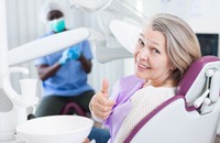 woman giving a thumbs-up before dental implant surgery