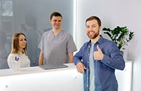 Happy patient standing at dental office front desk