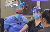 Three dental professionals wearing face masks