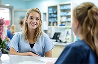 Two people sitting at desk, discussing paperwork
Patient and dental team member at front desk